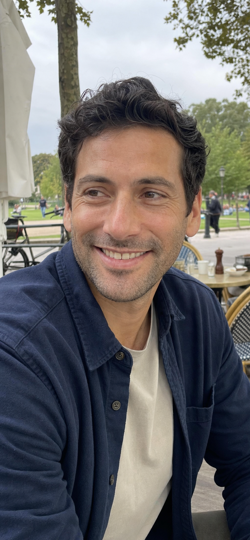Daniel sonríe en una cafetería junto a un parque